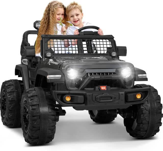 Two children sit in a red 24V/4WD Xtreme Ride on Truck with Eva wheels and leather seats. One holds a flower, and the other pretends to drive. The toy cars headlights and grille give it the adventurous look of a rugged vehicle, ready for off-road escapades.