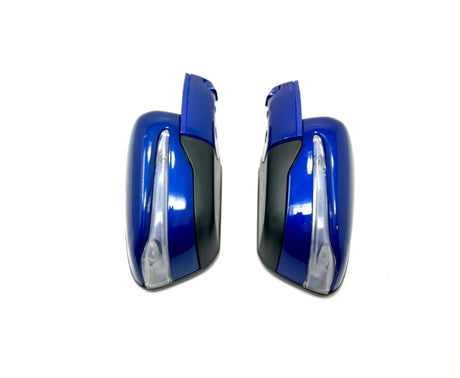 The 12V Mercedes X Class Pair of Mirrors features shiny blue side mirrors with black accents and integrated turn signals, shown facing each other on a white background. Ideal for upgrading your ride-on car experience. Final Sale—contact us to learn more!.