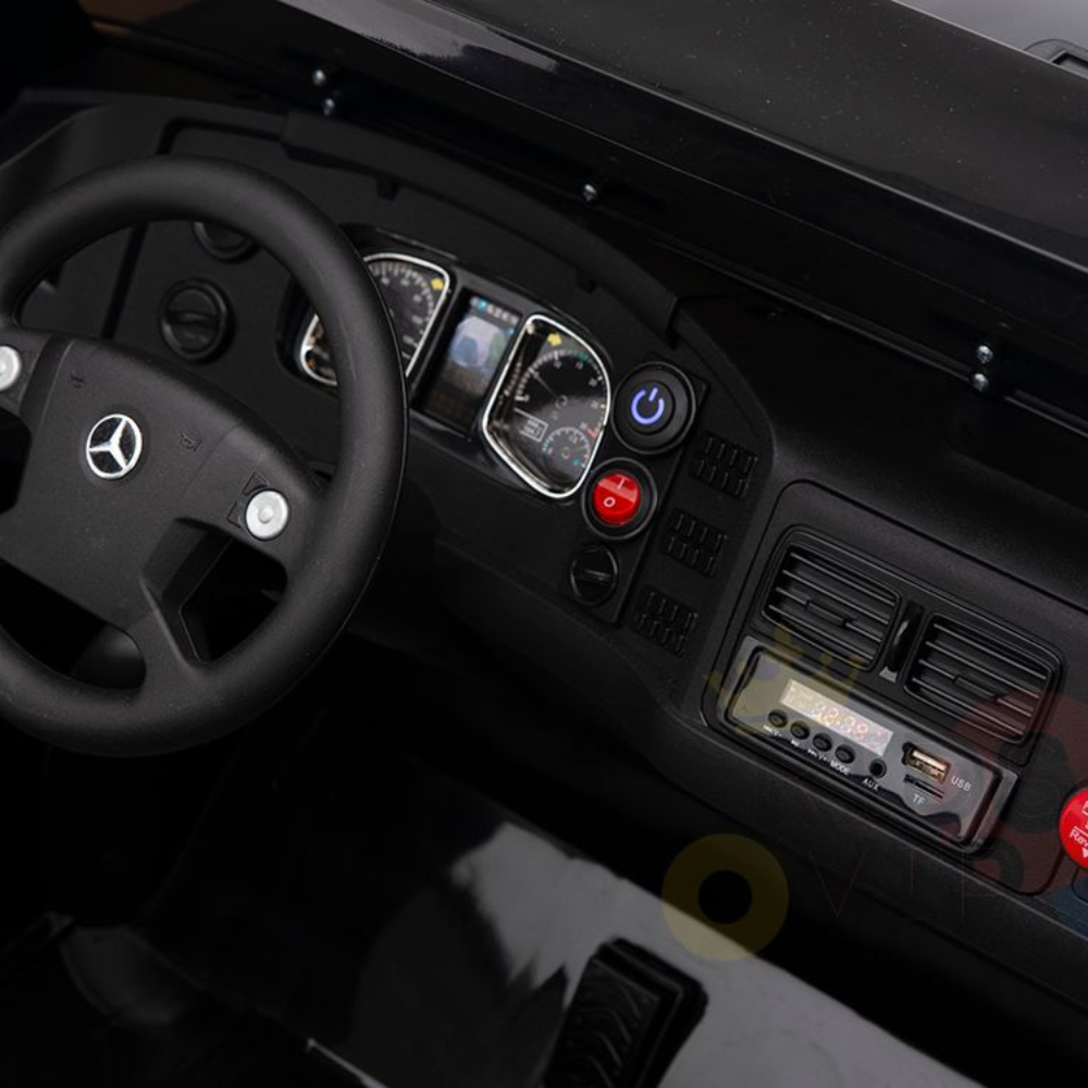 Close-up of a sleek car dashboard with a Mercedes logo on the steering wheel, akin to the Black 24V XXL Mercedes Benz Zetros Kids Ride On Truck. It features a speedometer, control buttons including a red one, air vents, and a digital display with USB ports, mirroring its modern design.