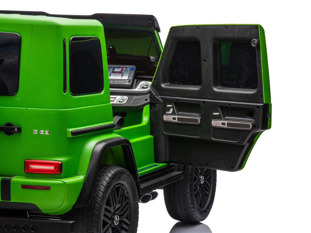 A Green Mercedes G63 XXL 24V Kids Ride-On Truck – Platinum Edition with MP4 and dual batteries showcases its modern interior and sleek black accents. With remote control access, two-window rear doors, EVA tires, and leather seats, it is parked against a white studio background.