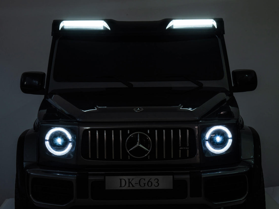 A green Mercedes G63 XXL Platinum Edition Kids Ride-On Truck with LED headlights is shown from the front. The license plate reads DK-G63. This 24V/4WD vehicle, offering remote control access, is set against a dark background.