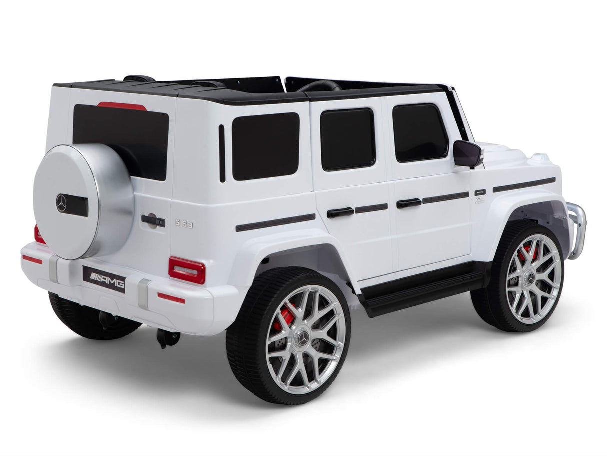 The 2 Seats 4x4 Official Mercedes Benz G63 Complete Edition White 24V Kids Ride On Car with RC is a luxury SUV toy featuring four large wheels, tinted windows, a rear spare tire, and black trim for an elegant look. Enjoy the ride-on experience powered by its efficient 24V battery.