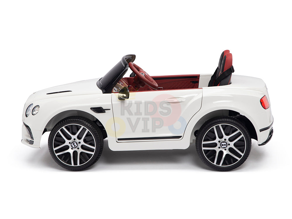 This White 12V Bentley GTC Kids Licensed Ride-On Car features a red interior, leather seat, rubber wheels, and detailed headlights. A black steering wheel and Kids VIP label add luxury for little drivers. Comes with a remote for enhanced control.