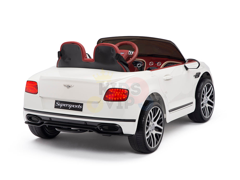 The White 12V Bentley GTC Kids Licensed Ride-On Car features a stylish convertible design with red and black leather seats, realistic wheels, a Supersports label on the back, seating for two, and includes a remote control for fun and safety.