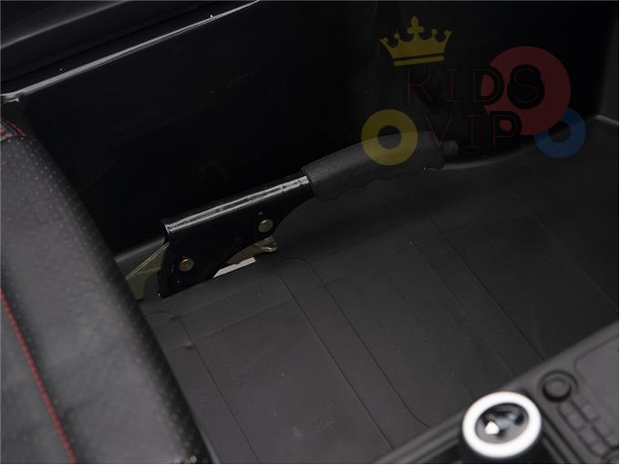 Close-up of a cars interior showcasing a handbrake with a comfortable grip and ECO leather seats in black upholstery with red stitching. Part of the control panel and RIDS VIP logo is seen, echoing the sophisticated 24V SuperSport vehicles by KIDSVIP, like the Black 24V XXL SuperSport Big Kids Ride On Car.