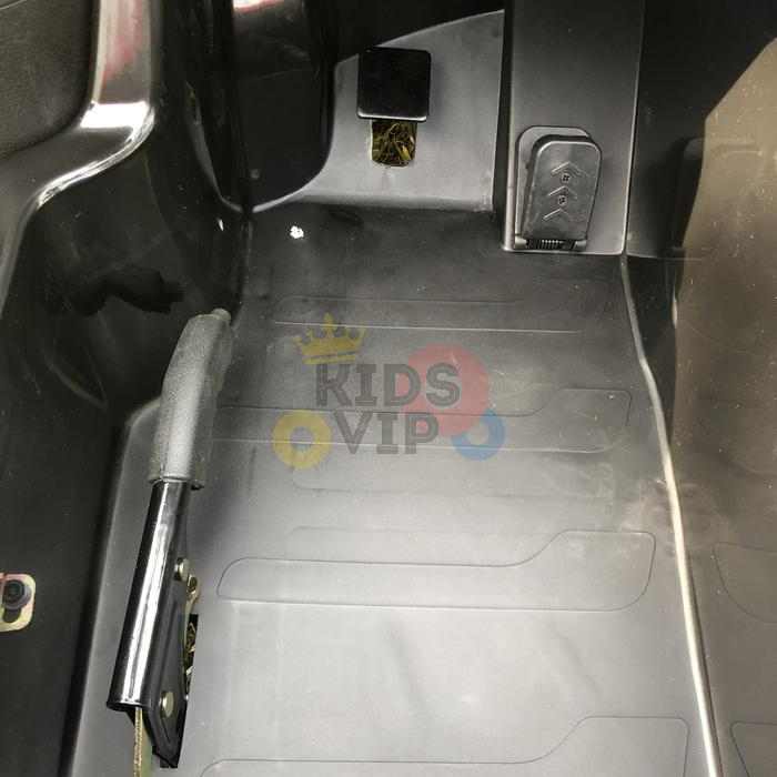 The interior of the Orange 24V XXL SuperSport Big Kids Ride On Car showcases the floor with a pedal and lever, complete with the Kids VIP logo on the mat. It features authentic details like a 180W brushless motor and real air-filled tires for a realistic driving experience.