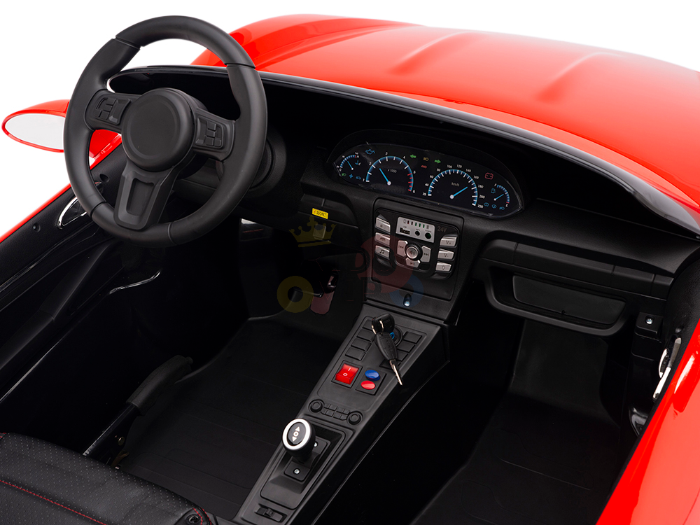 The image displays the interior of a Red 24V XXL SuperSport Big Kids Ride On Car, showcasing a black steering wheel, dashboard with speedometers, console controls, and an ignition with a key. The seat and floor are black and powered by a 180W brushless motor with real tires.