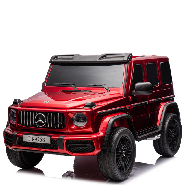 This Red Metallic 2x24V/4WD Platinum XXL Mercedes G63 Ride-On Truck resembles a mini G-Wagon, featuring black tinted windows, detailed front grille with logo, large EVA wheels, leather seats, MP4 player, and remote control access. License plate: DK-G63.