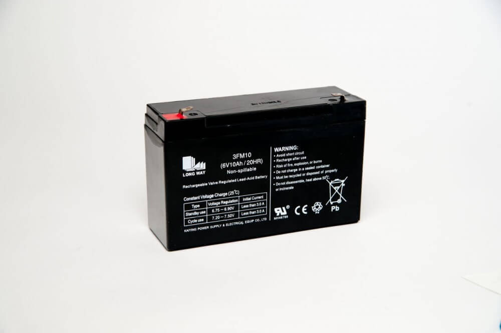 The Power up Your Ride with a 6V 7amp Battery for Cars: Unleash Endless Fun! is a black rectangular sealed lead-acid battery. It features clear specifications and warnings, with red and black terminals at opposite corners, ideal for replacing ride-on car batteries against a plain white backdrop.