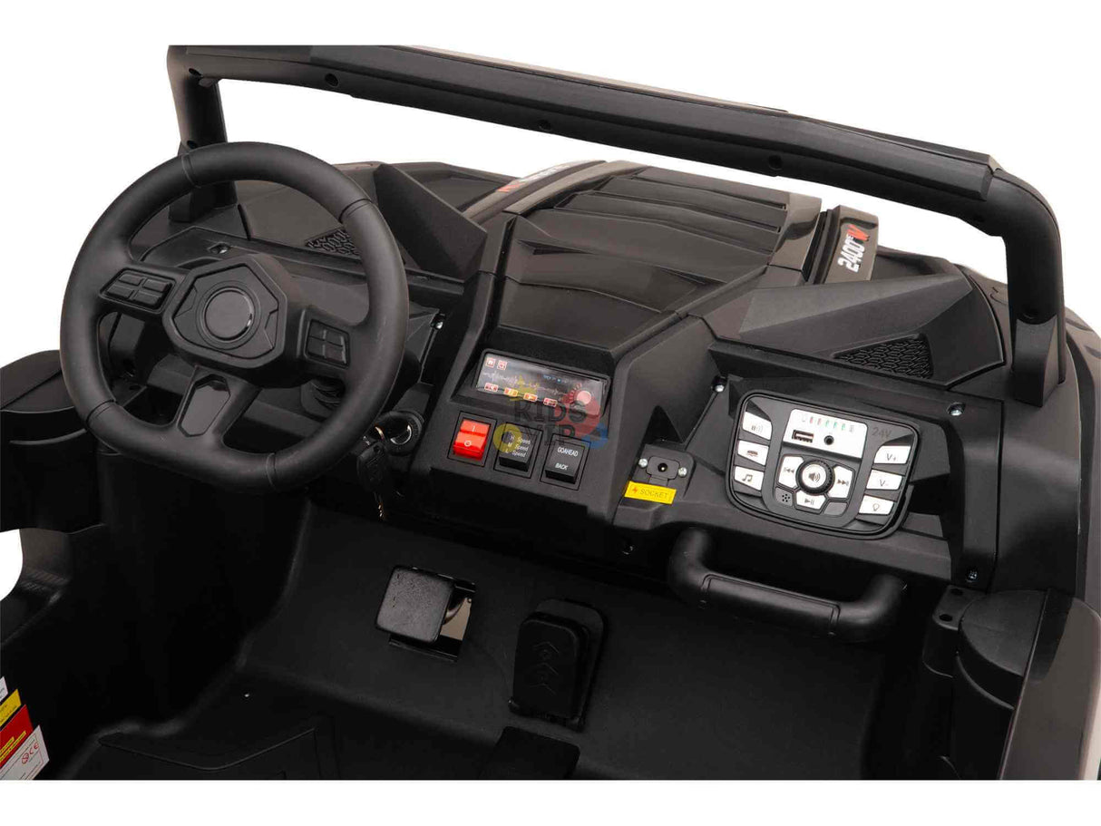 Interior view of the Black 24V/180W XXL Big Kids Blade XR Ride on Buggy dashboard, showcasing a steering wheel, various controls, buttons, and a display. The design mirrors that of an off-road vehicle or ATV with intricate detailing in line with the XXL Blade XR Edition.