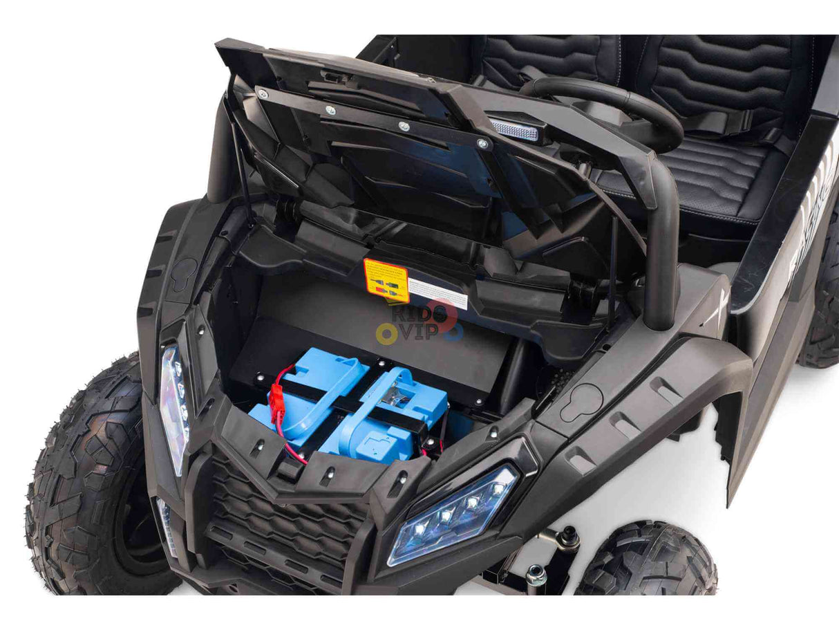 The Black 24V/180W XXL Big Kids Blade XR Ride on Buggy reveals intricate mechanics with an open hood, blue batteries, black wiring, and a small yellow component. It boasts ECO Leather Seats and inflatable rubber tires that enhance the exposed black wheels for authenticity.