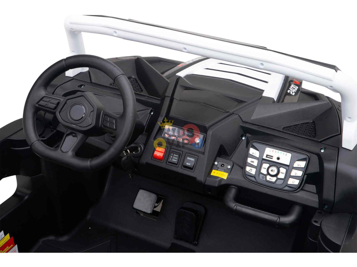 Interior view of the White 24V/180W XXL Big Kids Blade XR Ride-on Buggy displays a steering wheel, dashboard, and control panel with buttons and a digital display. It mirrors real car features with its black color scheme, white roll bar, and inflatable rubber tires for a smooth ride.