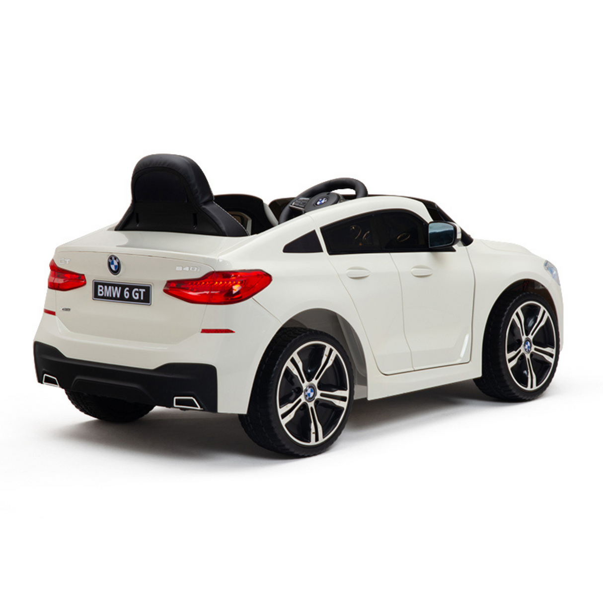 A rear-side angle image shows a white 12V BMW GT Kids Licensed 1 Seater Ride On Car with Rubber Wheels, Remote. It features a sleek design, black seats, realistic detailing, and prominent wheel rims against a plain white background.