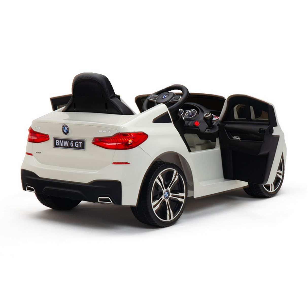 The White 12V BMW GT Kids Licensed 1 Seater Ride On Car features rubber wheels, a black interior, opening doors, steering wheel, and detailed dashboard. With a BMW 6 GT license plate and remote control, this toy offers an authentic experience resembling a real BMW.