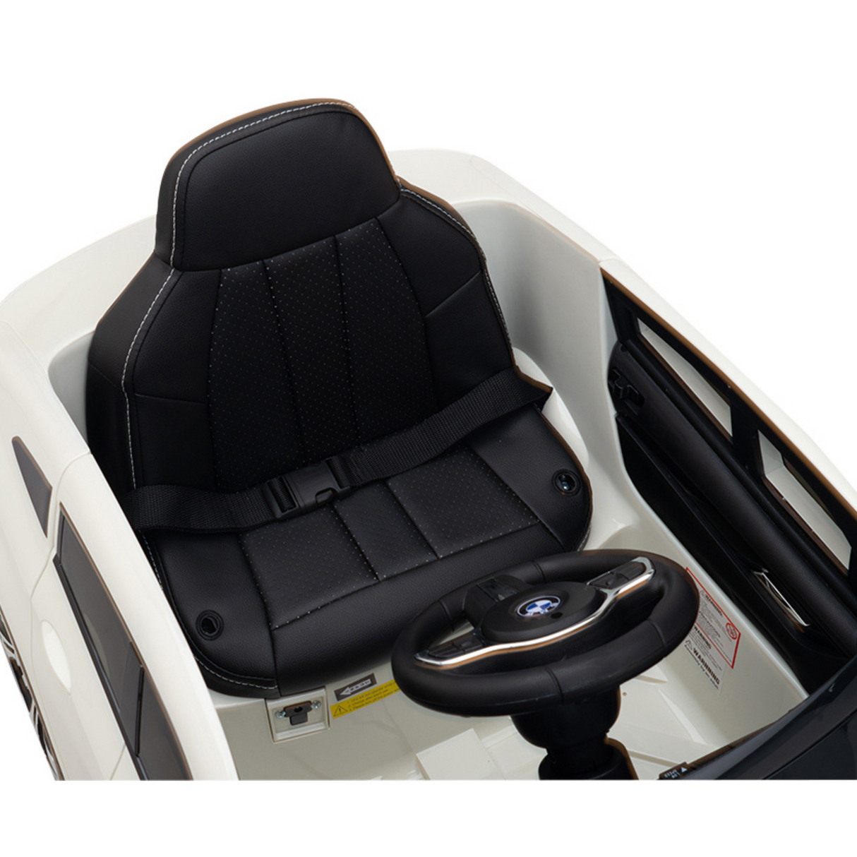 The White 12V BMW GT Kids Licensed Ride-On Car features a sleek black leather seat with a seatbelt and an iconic logo on the steering wheel, offering an authentic luxury experience for your child in a primarily white design.