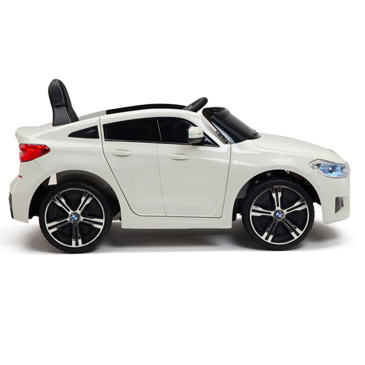 A side view of a white 12V BMW GT Kids Licensed 1-Seater Ride On Car shows its modern sports car design, featuring black seats, large rubber wheels, headlights, and mirrors. Suitable for children, it includes a remote control for added safety.