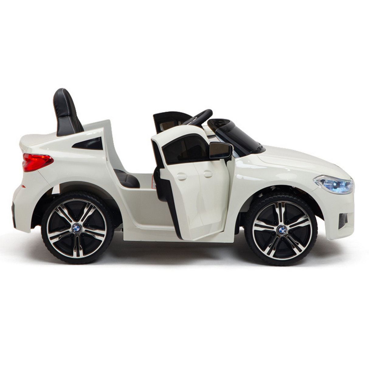 This 12V BMW GT ride-on is a licensed white convertible for kids with rubber wheels, black seats, open doors, and a realistic design. The perfect one-seater for your little driver. Includes remote control for convenience.