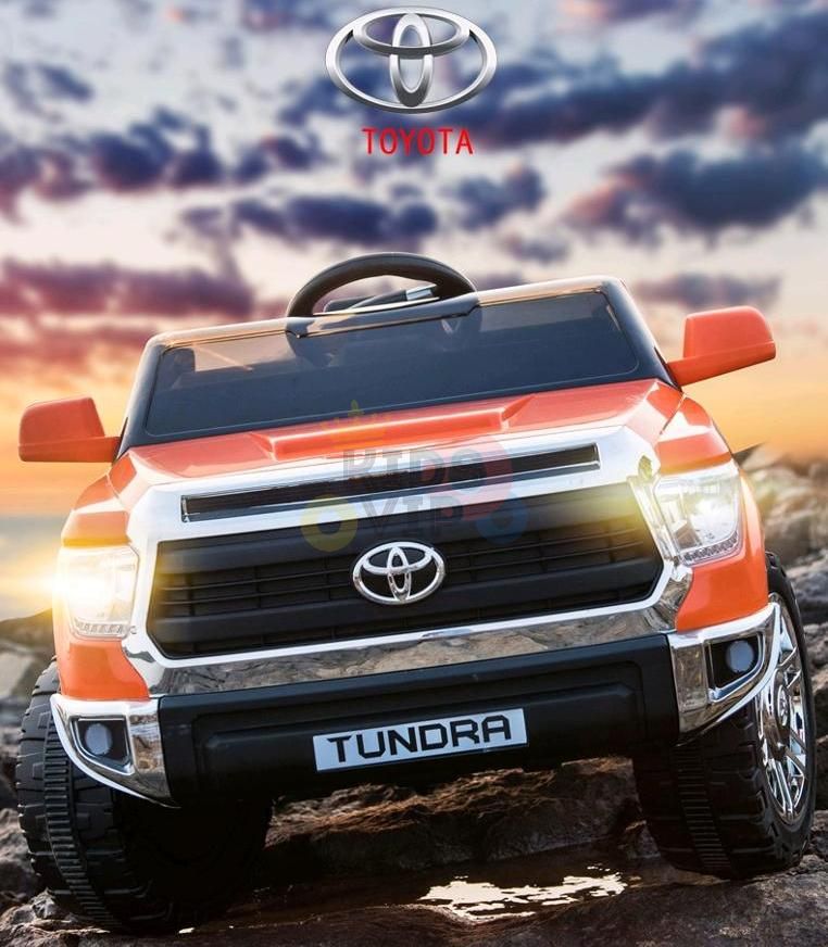 An Orange 12V Licensed Upgraded Toyota Tundra 1 Seater Kids Ride On Truck with RC is showcased against a sunset, featuring the iconic Toyota logo prominently.