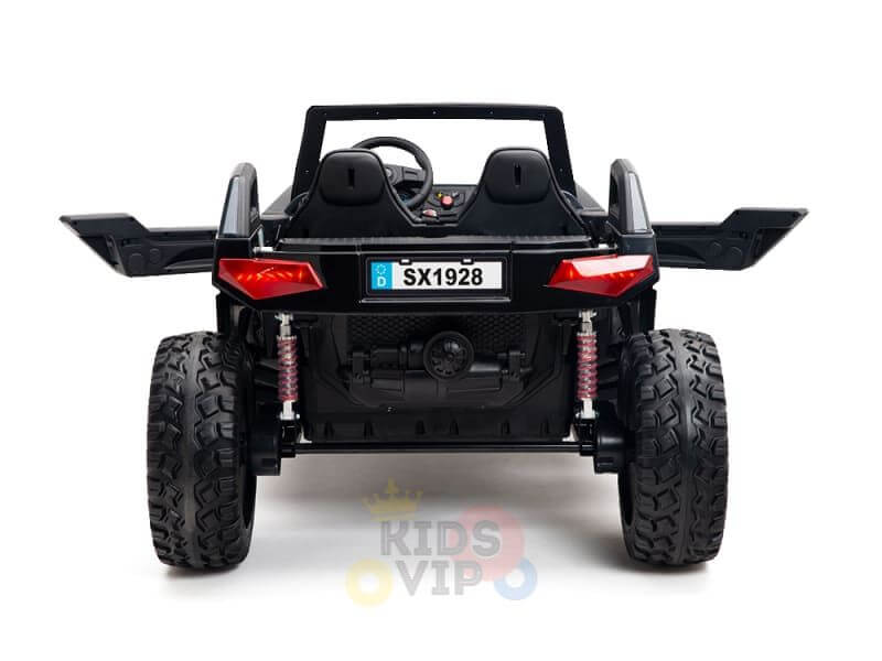 The rear view of a Kids XXL Black 24V/4X4 Dune Buggy Ride On UTV features large off-road rubber wheels, a small steering wheel, SX1928 license plate, red taillights, visible suspension springs, and the KIDS VIP logo.