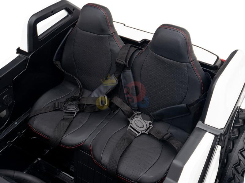 Close-up of black leather seats with red stitching in the White 24V/4X4 Dune Buggy Ride On UTV. These seats, featuring seat belts and a minimalist design, showcase the small-scale craftsmanship perfect for the Kids XXL Edition.