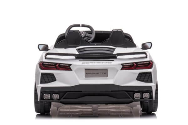 Rear view of the Kids Premium 24V White Corvette C8 Dual-Seater reveals sleek taillights, dual exhausts, visible steering wheel, and two leather seats. The toy rests on durable EVA wheels for smooth rides against a plain white background. Comes with remote control.