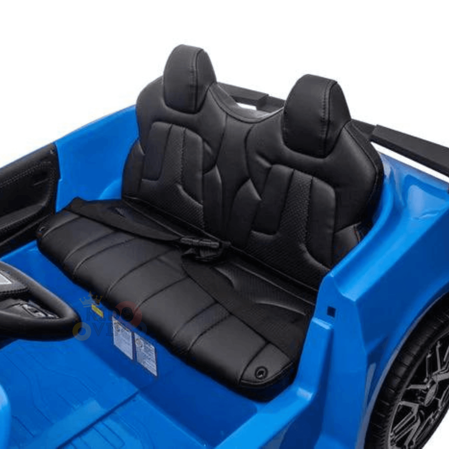 The Kids Premium 24V Blue Corvette C8 Dual-Seater features a sleek interior with two black leather-look seats and a small black steering wheel on the left. Designed for children, this stylish car boasts EVA wheels and eye-catching side stickers. The seats offer a modern design perfect for young racers.