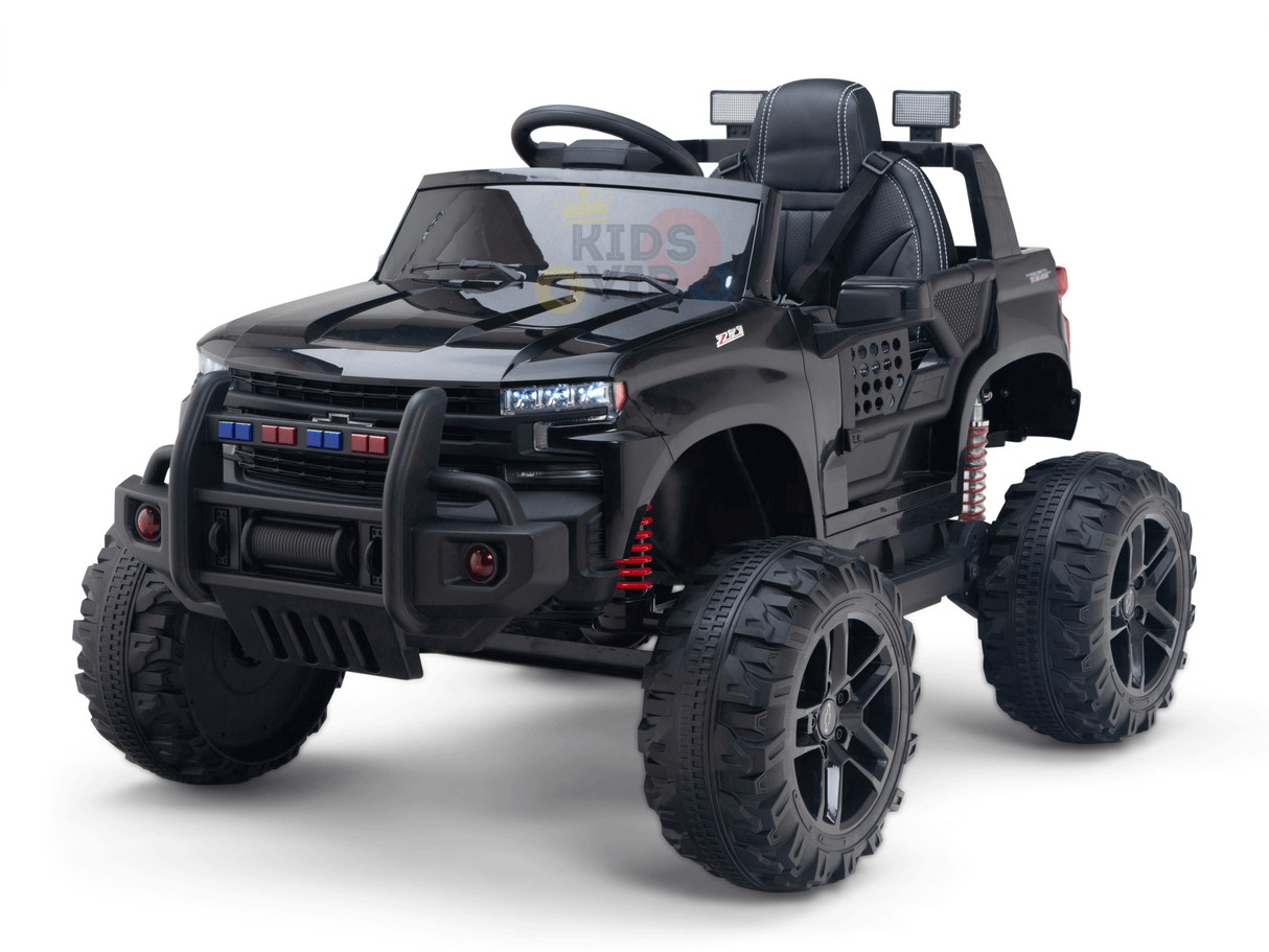 The Black Official 24V Chevrolet Silverado Lifted Kids Ride-on Truck features large wheels, headlights, and a steering wheel. It includes red suspension springs and intricate details that mimic an off-road vehicle, with the KIDS text faintly visible on the windshield.