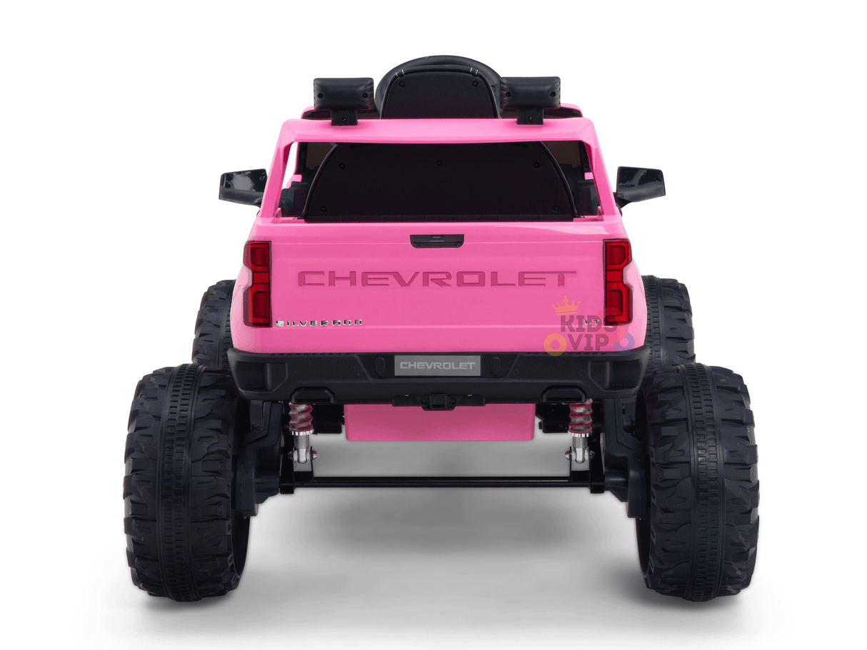 A pink 24V Chevrolet Silverado Kids Licensed 1 Seater Ride On Lifted Truck features large black tires, CHEVROLET emblems on the tailgate, and a rear-mounted spare tire, capturing adventure in a vibrant ride.