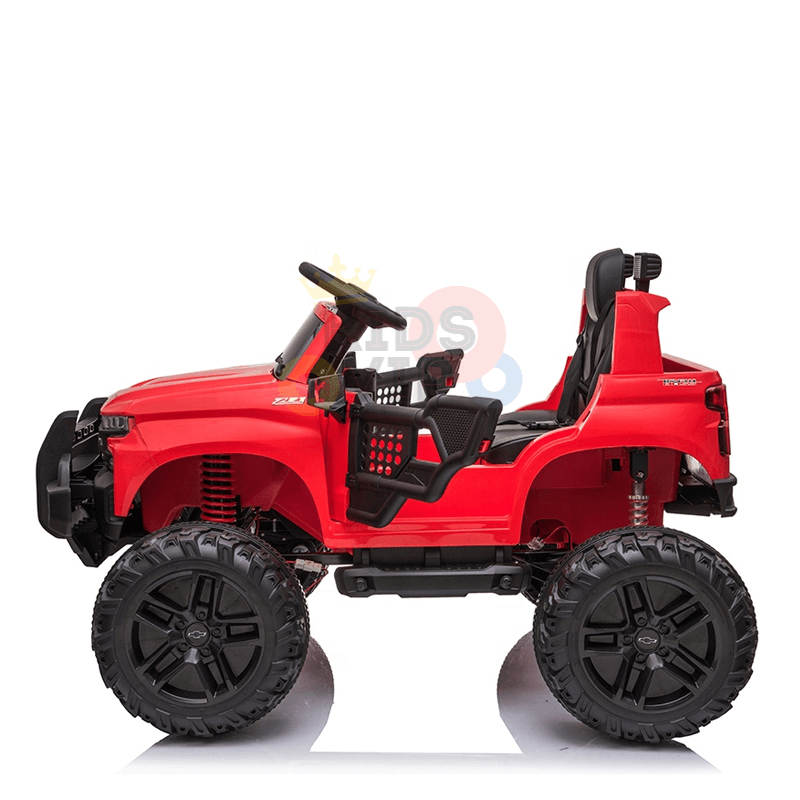 The Red 24V Chevrolet Silverado Kids Licensed 1 Seater Ride On Lifted Truck features oversized black wheels, an open-top design, and a steering wheel on a white background. This toy captures the adventurous spirit of off-road vehicles for kids.