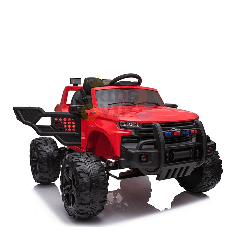 The Red 24V Chevrolet Silverado Kids Licensed 1 Seater Ride On Lifted Truck with Remote sports oversized black wheels, a bull bar, side mirrors, detailed front lights, and a black grille. Its open back and rugged design make it ideal for outdoor play adventures.