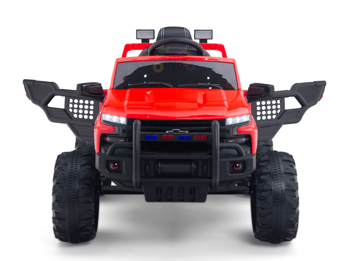 The Red 24V Chevrolet Silverado Kids Licensed 1 Seater Ride On Lifted Truck with Remote features oversized wheels, black accessories like a grill guard and side mirrors, openable doors with a steering wheel inside, and front LED lights alongside police-style blue and red lights.