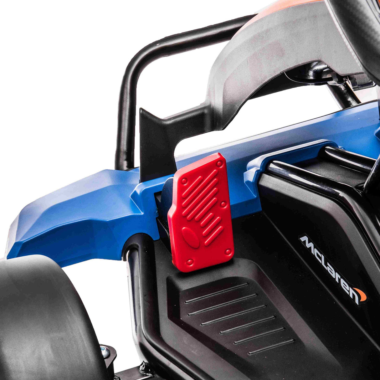 Close-up view of the steering wheel and seat area of an Orange 24V Official Complete Edition McLaren Super Drifting Go-Kart. The word McLaren appears on the black panel near the footrest. This kids ride-on features a sleek orange design with textured detail, ideal for drifting adventures.