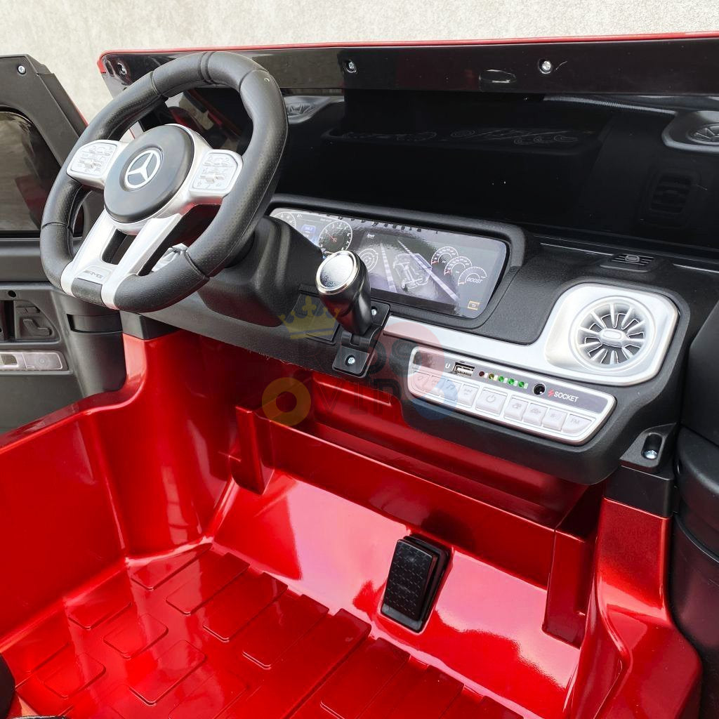 Styled as a Mercedes Benz G63, the 2 Seats 4x4 Kids Ride On Car features detailed steering and dashboard elements, faux gear shift, pedal, vibrant red cockpit design, and runs on a powerful 24V battery.
