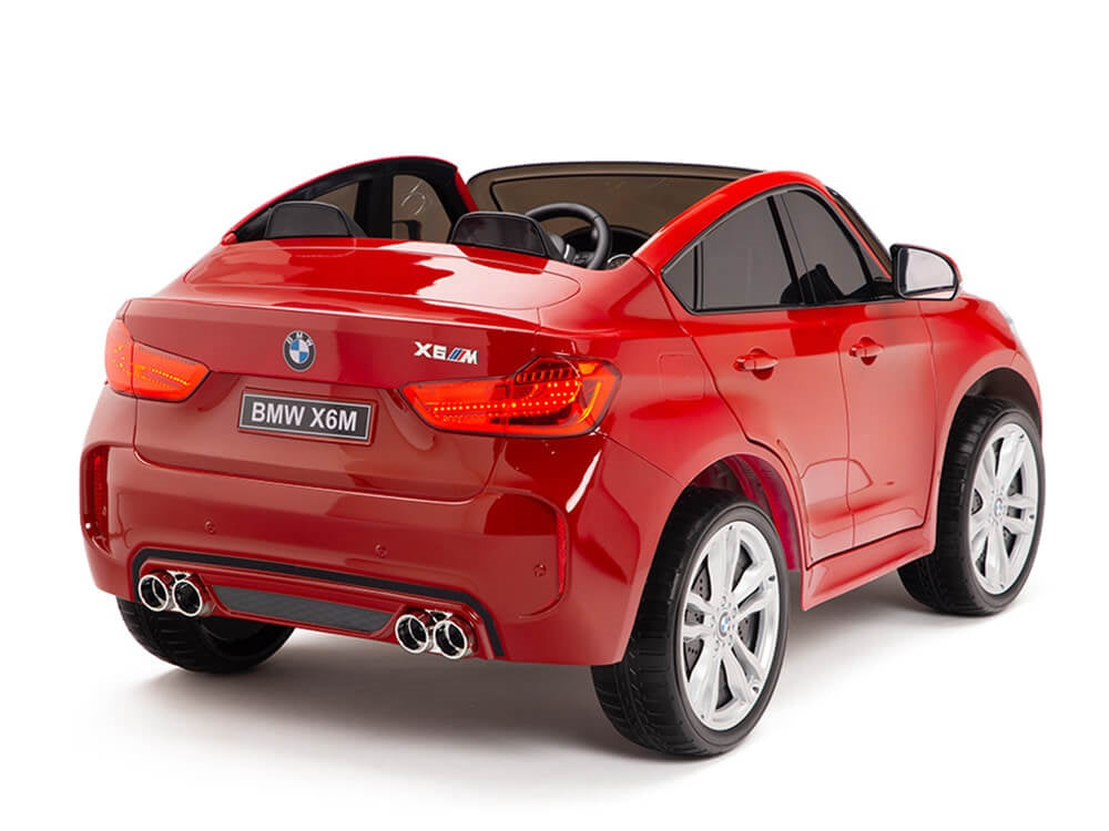 The Red 12V Licensed XXL BMW X6 Ride On Car features a sleek design, shiny finish, detailed features, large silver wheels, a BMW X6M license plate, and dual exhaust. With remote control capability, its a thrilling ride for little racers.