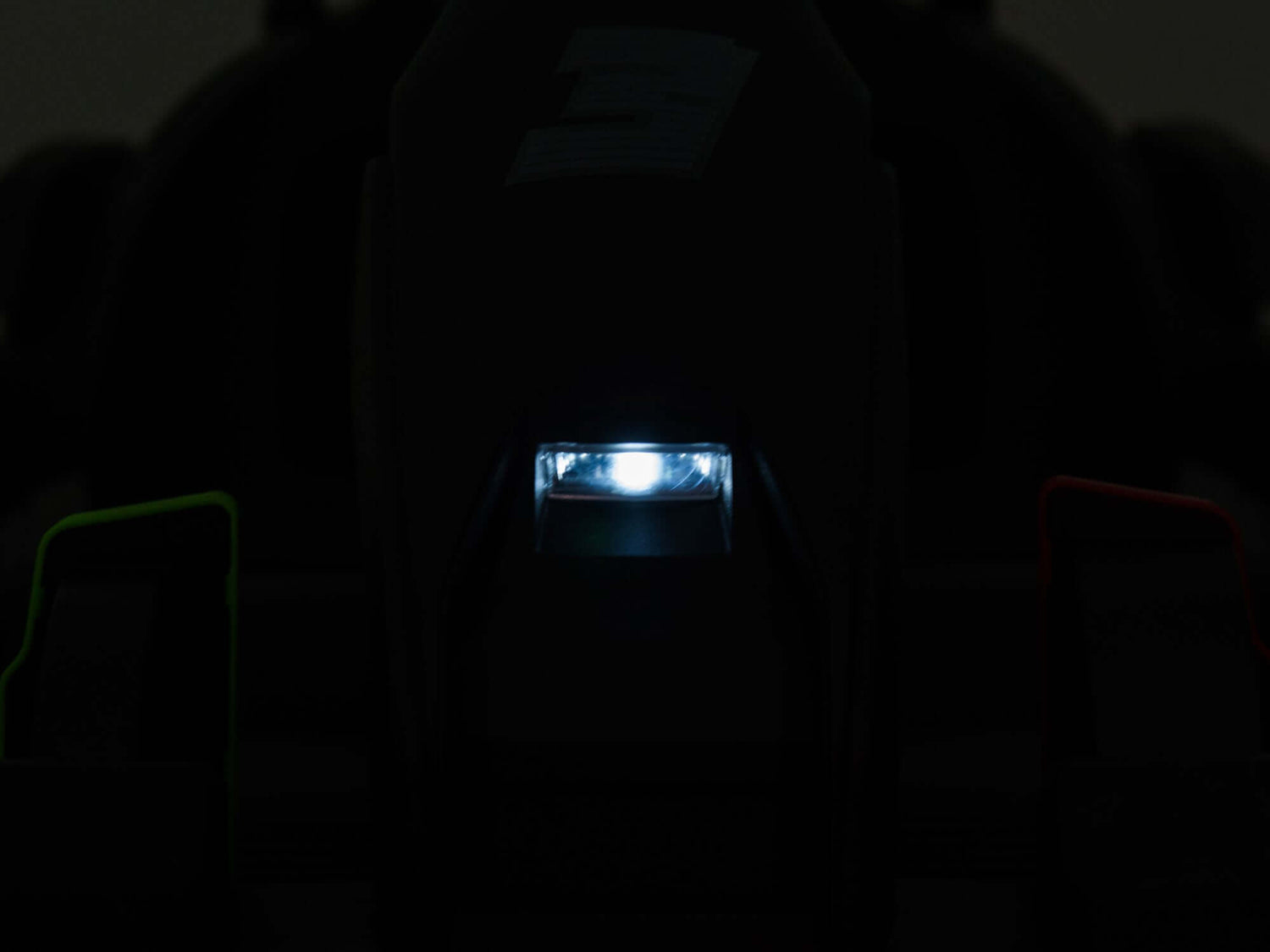 A dark image shows a brightly lit, small rectangular light at the center of a black, indistinct object. Faint green and red hints glimmer on either side, reflecting the excitement of a Big Kids Powerful 24V Speedster Drifting Go-Kart.