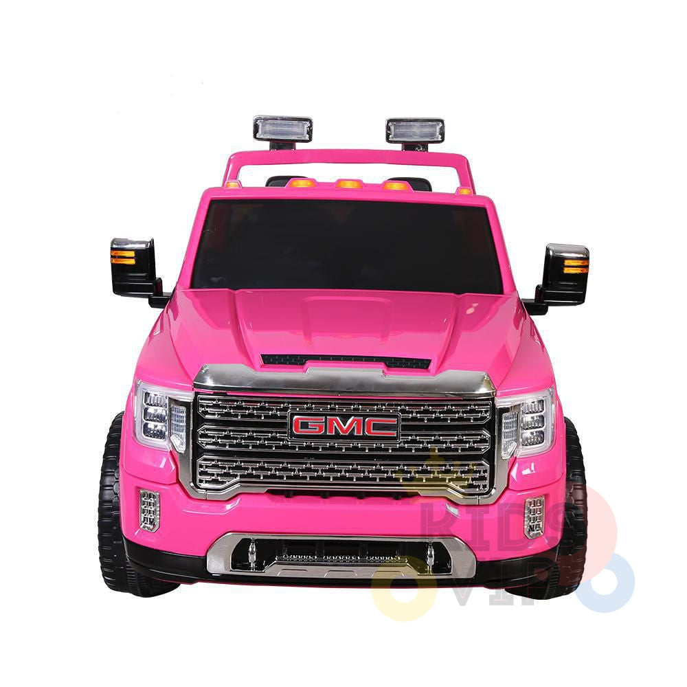 The Pink 2x12V Licensed 4WD GMC Sierra Kids Ride On Car with RC features a bright pink color, chrome grille, large black wheels, realistic headlights, and authentic front bumper and roof lights for an exciting design.