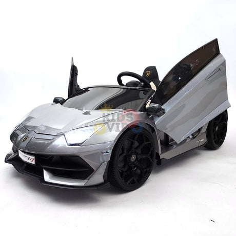 The Upgrade Your Ride: Experience the Thrill of Drifting with the Complete Edition 24V Lamborghini Sport Car is a shiny gray ride-on resembling a real sports car, with open scissor doors, black wheels, and a steering wheel on a white background. Enjoy peace of mind with the KidsVip warranty.