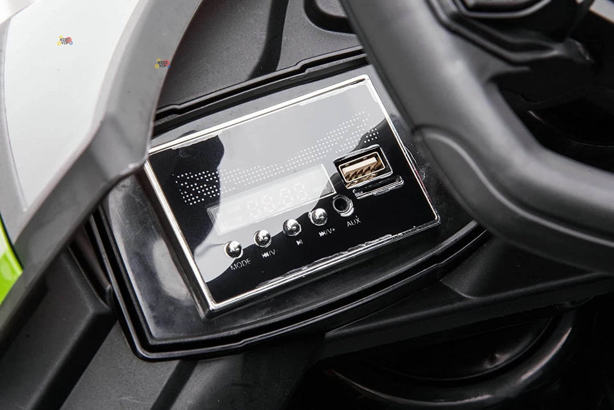 Close-up of the Green 12V Official Lamborghini Vision GT Kids Ride-on Car dashboard, showcasing a sleek black stereo system with buttons for MODE, VOL⁺, VOL⁻, and AUX, plus a USB port and digital display, inspired by the Lamborghini Vision GT.