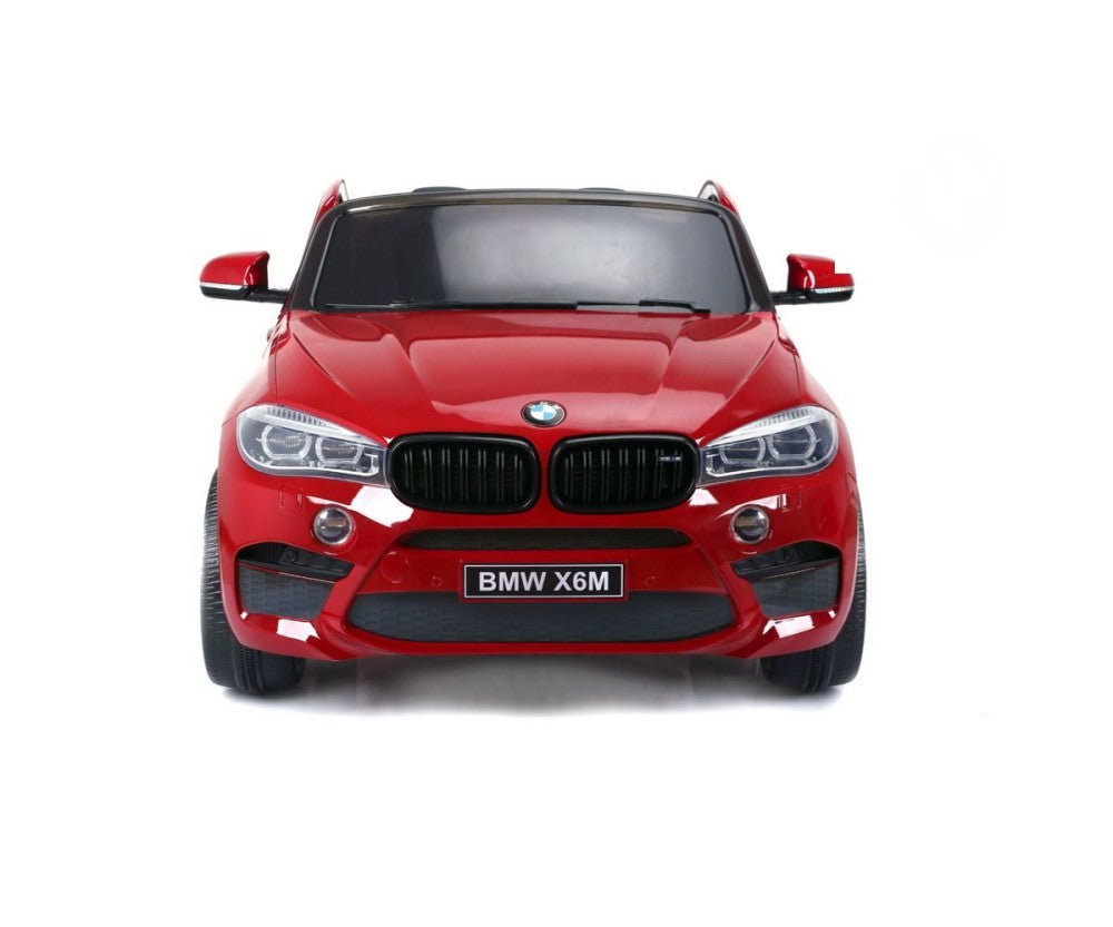 The Red 12V Licensed XXL BMW X6 Ride On Car features a stunning front view with a sleek black grille and bright headlights, displaying the license plate BMW X6M. Perfect for kids to enjoy thrilling rides with easy Remote Control functionality.