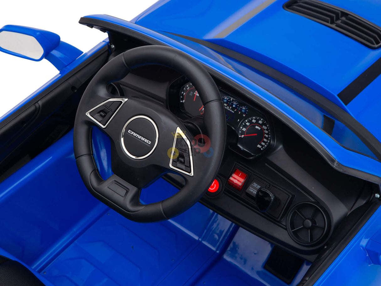 This close-up features a blue interior with detailed speedometers, switches, and a horn. The sporty steering wheel with a central logo mirrors the sleek design of the Blue Official Sport 12V Chevrolet Camaro Kids and Toddlers Ride on Car.