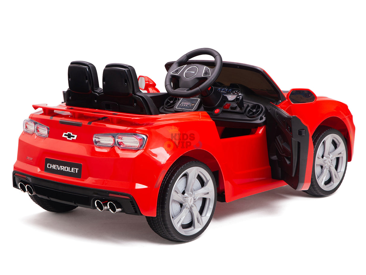 The rear view of the Red 12V Official Sport Chevrolet Camaro Kids and Toddlers Ride-on Car reveals detailed taillights, exhaust, silver wheels, black two-seat interior with steering wheel and dashboard, all on a white background with the drivers door open.