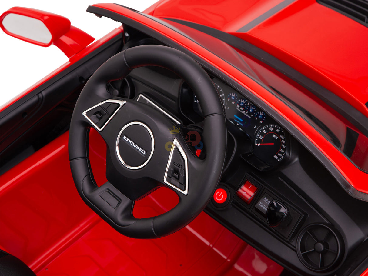 The Red 12V Official Sport Chevrolet Camaro Kids Ride-on Car features a red dashboard with steering wheel, speedometer, and buttons. The wheel has silver accents and a logo, while the battery powers the digital display and controls.