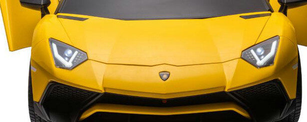 A close-up of a Yellow 24V/180W Lamborghini SV Limited XXL Edition ride-on sports car, featuring sleek angular headlights and eco-leather seats. Its smooth hood and partially open doors showcase a modern aerodynamic design and low front profile, reaching speeds up to 10MPH.