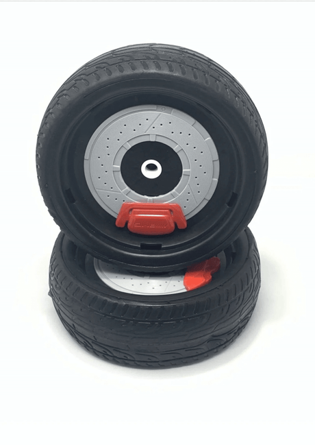 Two black toy car wheels stacked, displaying intricate tire treads and visible brake discs. A red brake caliper is prominently featured on the top wheel, akin to front wheels from the Enhance Your Bugatti Chiron with a Set of 12V Front Wheels, set against a pristine white backdrop.