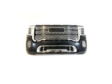 A black and chrome front bumper/grill with a center logo, mesh design, and integrated headlights on each side. Isolated against a white background, its perfect for the 12V/2 Seater GMC Sierra ride-on car enthusiast. Available exclusively as Enhance Your GMC Sierra: 12V/2 Seater Front Bumper/Grill Upgrade.