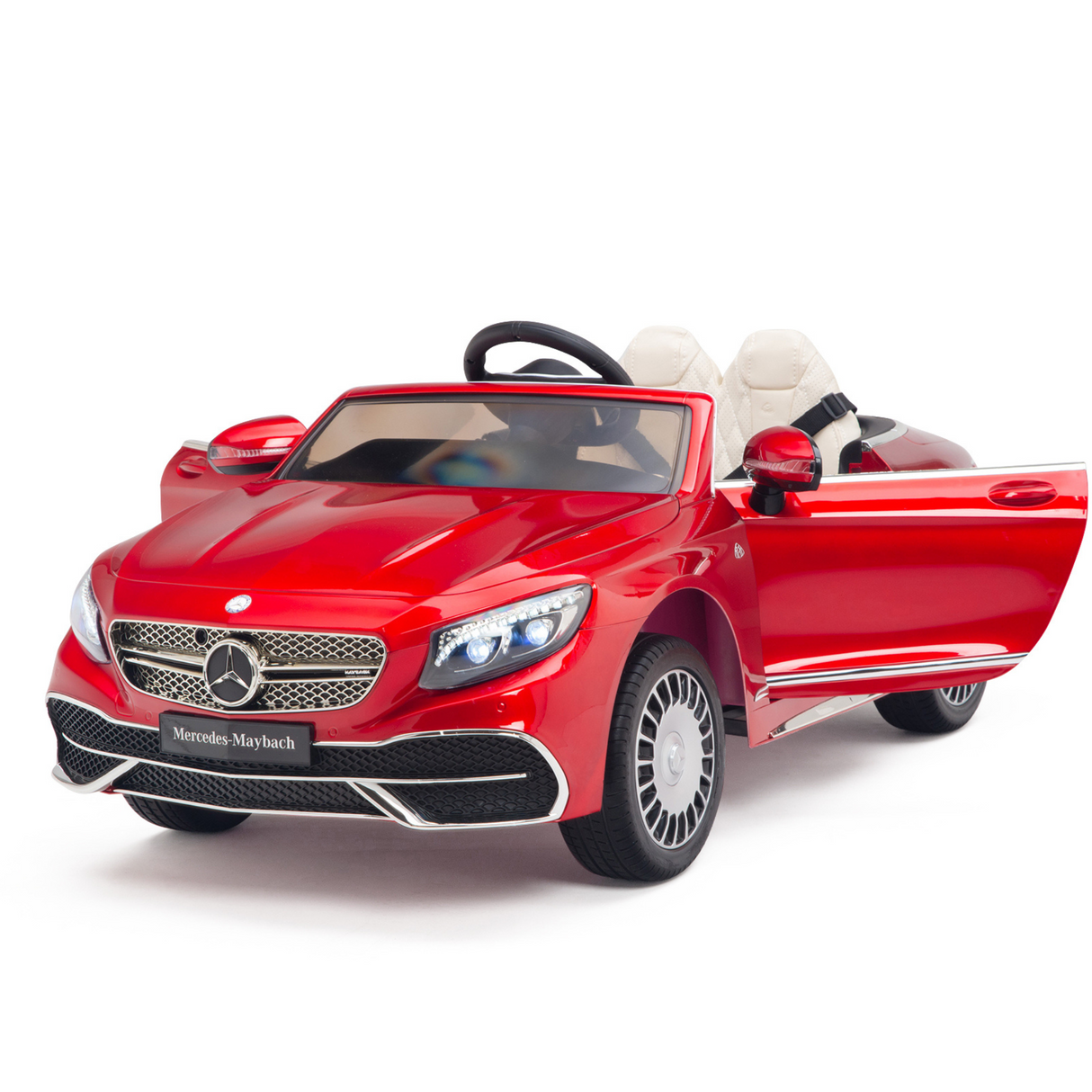 The Red 12V Mercedes Benz Maybach S650 Kids 1 Seater Ride On Car boasts an open drivers door, realistic headlights, grille, and wheels. Inside, a steering wheel and white seats enhance its luxury feel. Ideal for KIDS VIP experiences with rubber wheels for added durability.