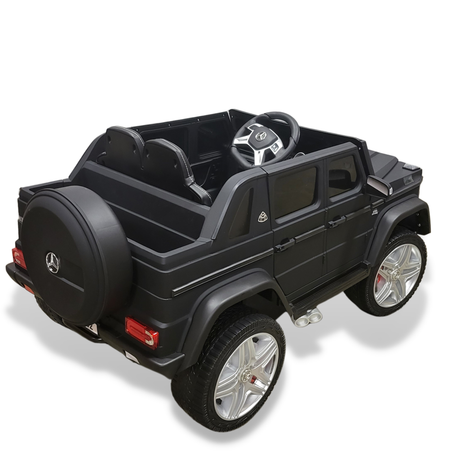 A matte black 12V Mercedes Benz Maybach G650s kids ride-on car with rubber wheels and a remote control. This luxury toy resembles the iconic G-Class, featuring an open top, detailed wheels, a rear-mounted spare tire, and visible steering wheel on a plain white backdrop.