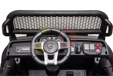 Close-up of a toy car dashboard featuring a steering wheel with the iconic Mercedes logo, evoking the Blue Official 12V Mercedes Unimog Junior 4X4 Kids Ride On UTV with Remote Control. A mesh screen sits above, surrounded by playful buttons and dials, ready for action.