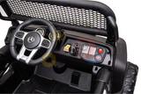 The Camo 12V/4X4 Official Mercedes Unimog Junior Ride On UTV has an interior with a steering wheel, dashboard controls, gear shift, and speedometer. Its mesh-style windshield and vibrant panel buttons embody the rugged essence of a Mercedes-Unimog.