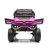 Front view of a Pink 12V/4X4 Official Mercedes Unimog Junior Ride On UTV, resembling a Mercedes-Benz jeep with large wheels, grille guard, and LED lights on a reflective white background—ideal for little adventurers dreaming of their own ride.